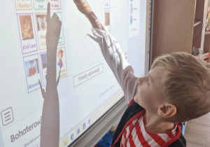 Oluś rozwiązuje quiz na tablicy multimedialnej.