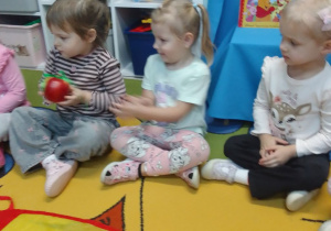 Dzieci przekazują sobie jabłko podczas dźwięków muzyki.