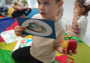 Olaf prezentuje obrazek z rekwizytem - kapeluszem z bajki "Kot w butach".