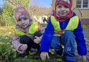 Oliwka i Antoś z dumą prezentują znalezione w ogrodzie grzyby