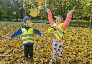 Marcel i Klara bawią się liśćmi w parku