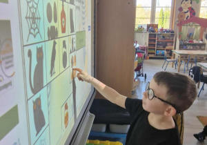 Antoś rozwiązuje quiz na tablicy multimedialnej