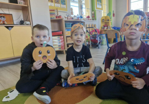 Nikoś, Ignaś i Wojtuś Z. trzymają w dłoniach obrazki z dyniami