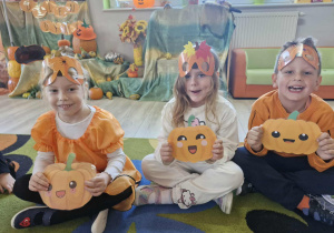 Nadia, Weronika i Franuś trzymają w dłoniach obrazki z dyniami