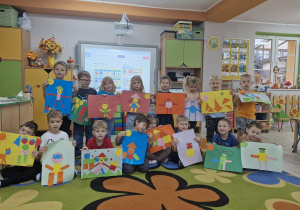 Dzieci z grupy "Biedronek" prezentują wykonane przez siebie geometryczne obrazki.