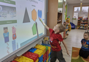 Olek na tablicy multimedialnej wskazuje figurę sześciokąta.