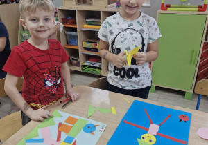 Olek i Franek siedząc przy stoliku tworzą swój geometryczny obrazek.