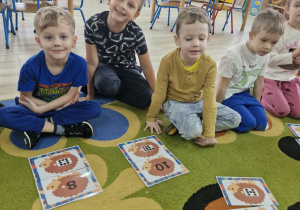 Oluś, Franuś i Marcel prezentują ułożone przez siebie karty matematyczne z wizerunkami jeży.