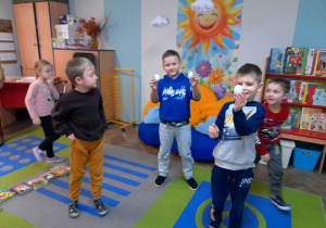 Pięcioro dzieci bawi się w poszukiwanie ukrytych w sali jajek.