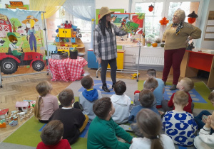 Dzieci słuchają książki czytanej przez zaproszonego gościa.