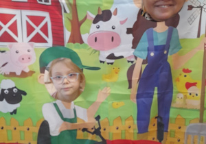 Zuzia i Pani Agata pozują do zdjęcia w fotobudce z motywem wiejskim.