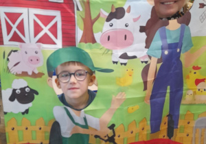 Mikołaj i Pani Agata pozują do zdjęcia w fotobudce z motywem wiejskim.