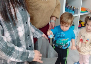 Nikodem i Hania wrzucają do worka jajka, które były ukryte w różnych miejscach na sali.