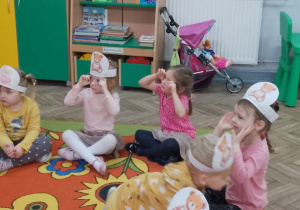 Dzieci siedzą w kole i interpretują ruchem treść wierszyka o misiu.