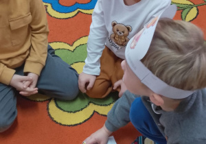 Trzech chłopców prezentuje ułożonego przez siebie misia.