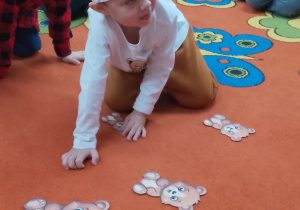 Trzech chłopców w trakcie zabawy z układaniem misiów według wielkości.