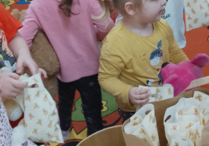 Dzieci po kolei częstują się upominkami.