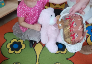 Felicja i Jagoda częstują się ciasteczkiem w kształcie misia.