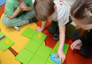 Leon i Nikodem kodują Myszkę - robota na zielonym polu.