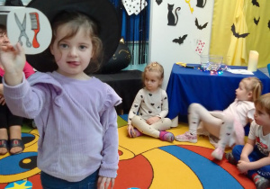Hania w halloweenowej czapce wylosowała obrazek z nożyczkami i grzebieniem.