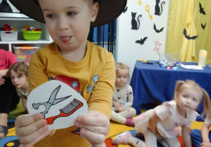 Olaf wybrał obrazek, na którym są nożyczki i grzebień.