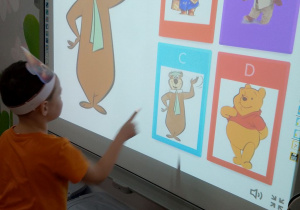 Antek na tablicy multimedialnej dopasowuje misie do pary.