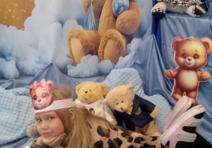 Dziewczynka pozuje do zdjęcia na tle dekoracji.