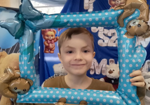 Bartek pozuje do zdjęcia w misiowej foto-ramce.