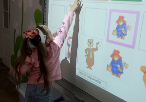 Amanda na tablicy multimedialnej dopasowuje misie do pary.