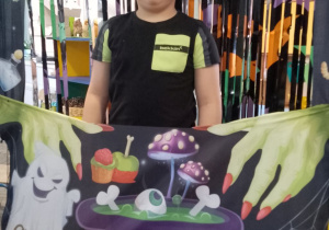 Kuba pozuje do zdjęcia w andrzejkowej fotobudce.