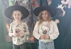 Ola i Weronika pozują do zdjęcia na tle andrzejkowej dekoracji.