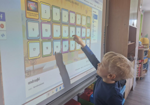 Karol losuje wróżbę na tablicy multimedialnej.