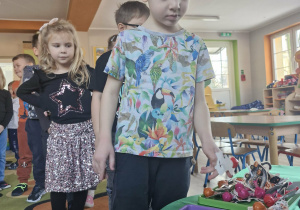 Dzieci częstują się medalionami szczęścia i andrzejkowymi lizakami.