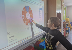 Julek w trakcie wróżb korzysta z tablicy multimedialnej.