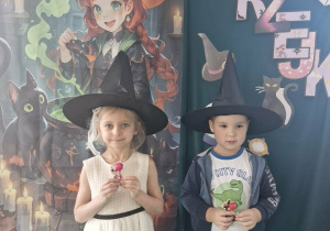 Lila i Szymek pozują do zdjęcia na tle dekoracji.