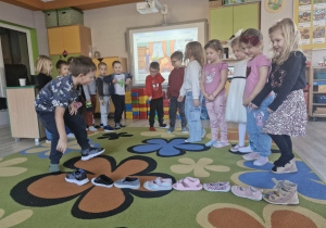 Dzieci w trakcie wróżby z przekładaniem butów.