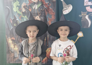 Wojtuś i Ignaś pozują do zdjęcia na tle andrzejkowej dekoracji.