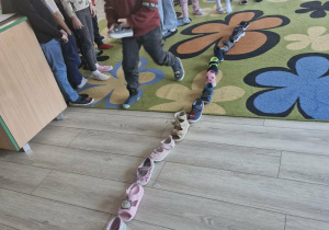 Tymuś przekłada swój but w trakcie wróżby z butami.