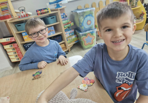 Tymek i Staś kolorują flamastrami misie.