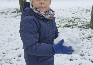Oskar trzyma w dłoniach śniegową kulę.