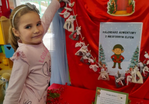 Marysia wyjmuje z kalendarza adwentowego pierwsze zadanie.
