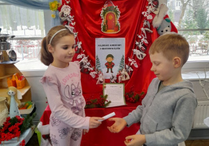 Marysia podaje Brunowi do przeczytania zadanie z kalendarza adwentowego.