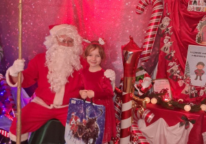 Emma pozuje do zdjęcia z Mikołajem.