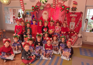 Zdjęcie grupowe z Mikołajem i otrzymanymi prezentami.