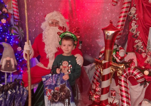 Kuba pozuje do zdjęcia z Mikołajem.