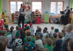 Muzyk gra na klarnecie kolędę pt. "Cicha noc", a dzieci razem z Panem prowadzącym zajęcia śpiewają.