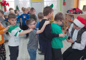 Dzieci stoją ustawione w pociąg, Pan przybija im pieczątkę na rączkach.