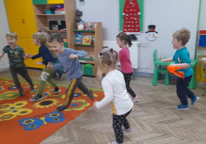 Dzieci z radością uczestniczą w zabawie ruchowej pt. "Berek banan".