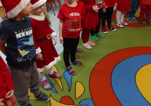 Pszczółki w czerwonych strojach podczas rozmowy z Mikołajem.