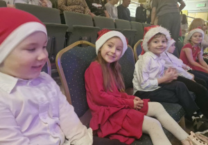 Dzieci siedzą na trybunach czekając na swój występ.